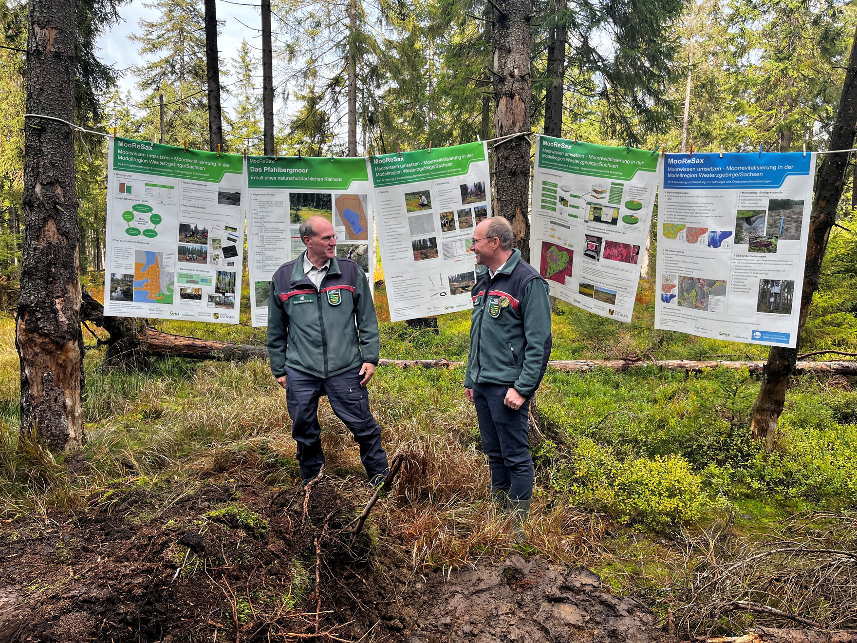 Utz Hempfling (links ) und Wolfram Günther im Wald vor einer Plakat-Präsentation.
